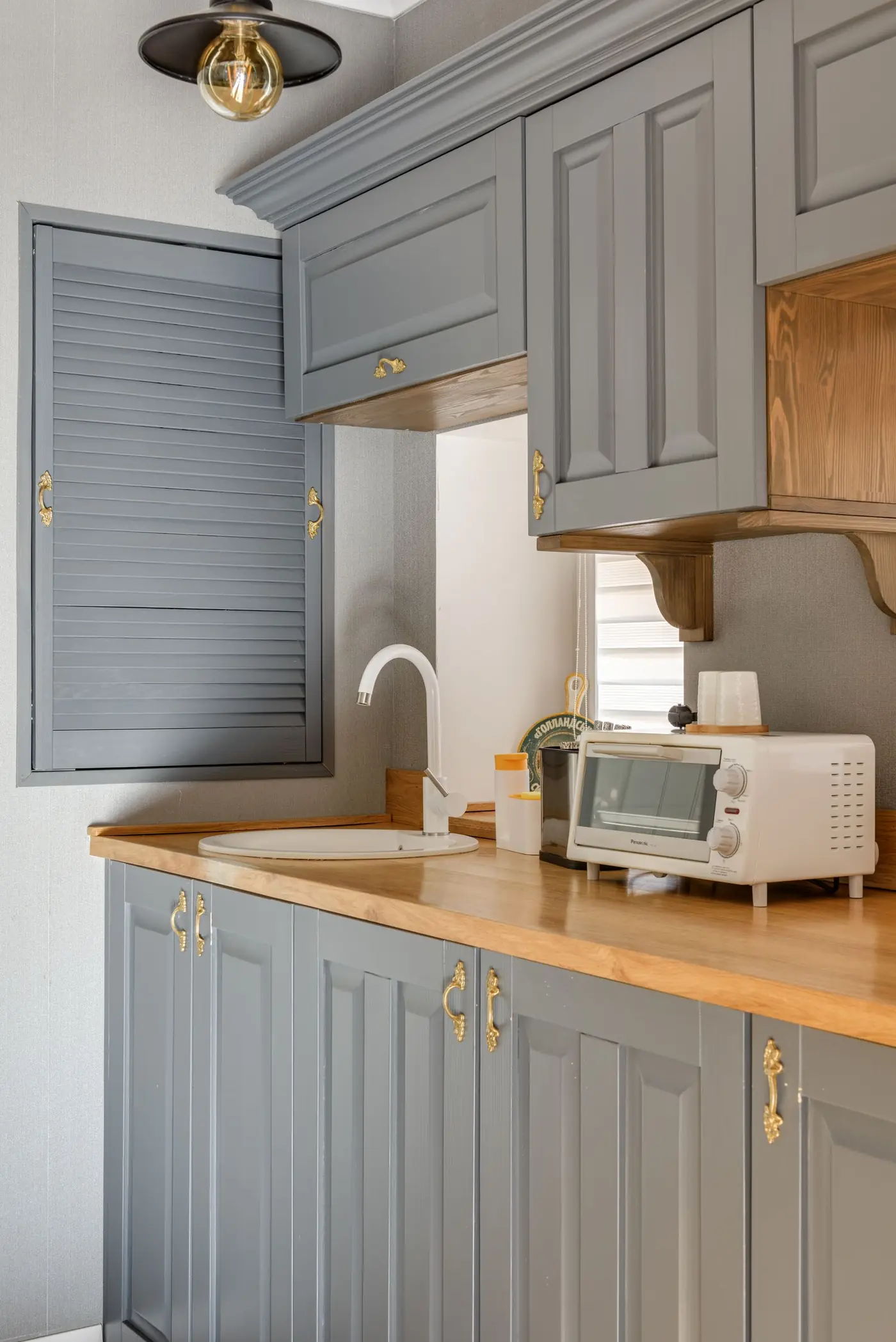 Cocina blanca con alacenas altas y barra de madera